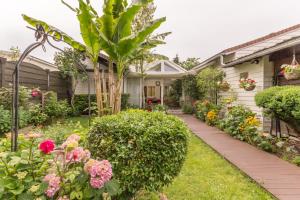 ein Haus mit einem Garten mit Blumen und Pflanzen in der Unterkunft L'ISLE DE FRANCE in Conflans-Sainte-Honorine