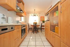 a kitchen with wooden cabinets and a table with chairs at Private Rooms Laatzen in Hannover
