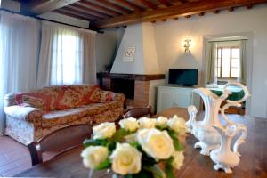 ein Wohnzimmer mit einem Sofa und einem Tisch mit Blumen in der Unterkunft Agriturismo Bellavista in San Miniato