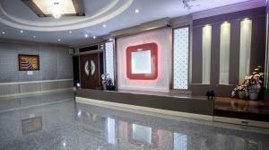 素辇府Maneerote Hotel的墙上有一个红色大标志的大堂