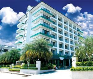 素辇府Maneerote Hotel的一座巨大的白色建筑，前面有棕榈树