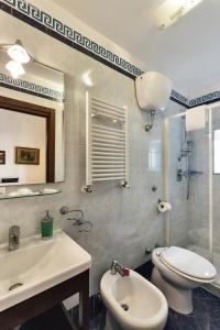 bagno con servizi igienici, lavandino e specchio di B&B Art Suite Principe Umberto a Napoli