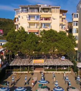 un grande edificio con tavoli e sedie di fronte di Espana aparthotel a Durrës