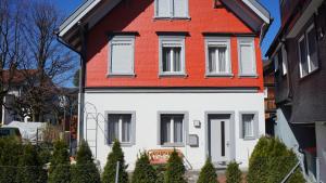 a white and red house with a red roof at Marktgasse 9 in Appenzell