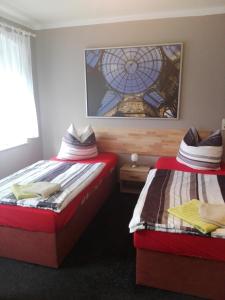 2 Betten in einem kleinen Zimmer mit Fenster in der Unterkunft Pension Hartmann in Görlitz