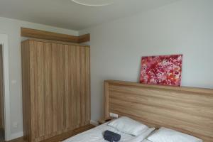 グダニスクにあるMy Old Town Gdańsk - Apartament Barbary 12のベッドルーム1室(ベッド1台、木製ヘッドボード付)