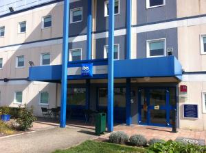 a building with blue poles in front of it at ibis budget Mâcon Nord in Mâcon