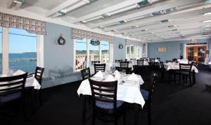 a dining room with white tables and chairs at Ocean View Hotel in Rocky Harbour