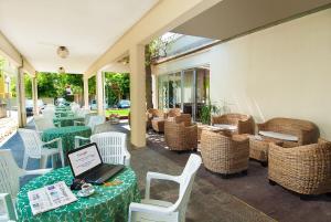 un patio con tavoli, sedie e un computer portatile sul tavolo di Hotel Le Querce a Senigallia