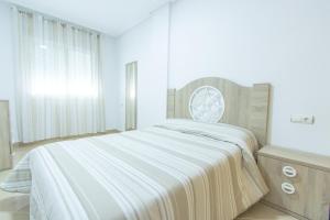 Un pat sau paturi într-o cameră la Apartamentos Completos III Carlos III