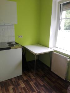 eine kleine Küche mit einem Tisch und einem Fenster in der Unterkunft Pension Hartmann in Görlitz