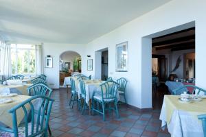 una sala da pranzo con sedie e tavoli blu e una balconata di Hotel Bel Tramonto a Marciana