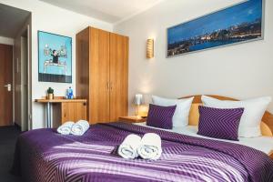 um quarto com uma cama grande e um cobertor roxo em Hotel Ambiente Berlin City em Berlim