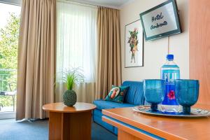 a living room with a blue couch and a bottle of water at Hotel Ambiente Berlin City in Berlin