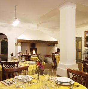 una sala da pranzo con tavolo e camino di La Locanda del Borgo a Pietralunga