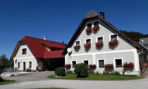 - un grand bâtiment blanc avec des boîtes de fleurs dans l'établissement Biobauernhof Obereck, à Göstling an der Ybbs