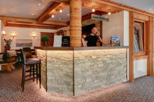 a man is standing at a bar in a restaurant at Landhaus Haake in Bad Zwischenahn