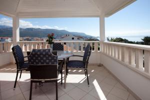 a porch with a table and chairs on a balcony at Villa Stobrec in Split