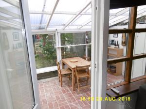 a conservatory with a table and chairs on a patio at 4 Louisenlund in Skanderborg