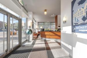 a lobby of a building with a sign on the wall at Hotel Conti Am Hauptbahnhof in M&uuml;nster
