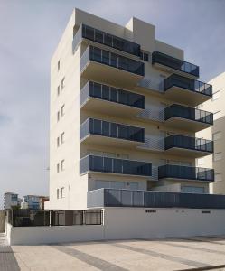 a white building with balconies on the side of it at Migjorn in Oliva
