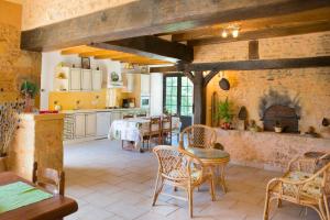 uma cozinha com mesa e cadeiras num quarto em Gîte de Vigne em Biron