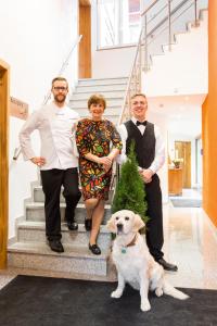 a family with a christmas tree and a dog on the stairs at Gasthaus zur Krone in Weingarten (Karlsruhe)