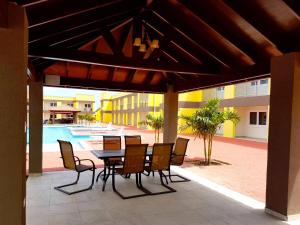 een patio met een tafel en stoelen en een zwembad bij Casa Alessandra 1bdr in Palm-Eagle Beach