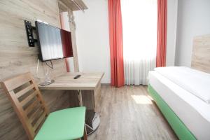 a bedroom with a bed and a desk at Hotel Pension Köberl in Munich