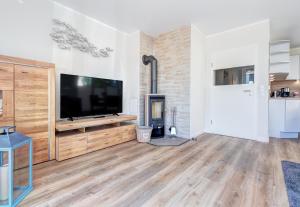 uma sala de estar com uma televisão de ecrã plano e uma lareira em Haus Wellenreiter em Bansin