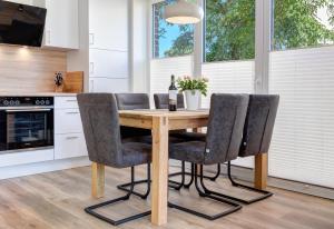 uma cozinha com uma mesa de madeira e cadeiras em Haus Wellenreiter em Bansin