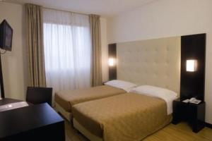 a hotel room with two beds and a window at San Marco in Montecchio Maggiore