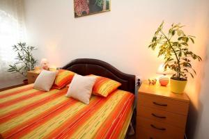 ein Schlafzimmer mit einem Bett mit zwei Kissen und einer Kommode in der Unterkunft 3 Platana in Palić