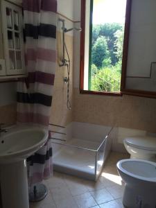 uma casa de banho com um chuveiro, um lavatório e um WC. em Villa immersa nel verde em Ischia