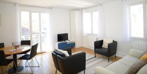 a living room with a couch and chairs and a table at Appart' Préférence in Lyon