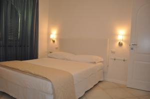 una camera con un letto bianco con due cuscini di Via Paradiso ad Amalfi