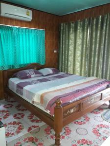 a bedroom with a large bed with blue curtains at Muean Fhan Resort Aranyaprathet in Aranyaprathet