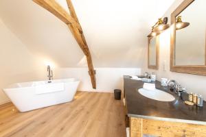 uma casa de banho com uma banheira branca e um lavatório. em L' Ecrin des vignes em Sermiers