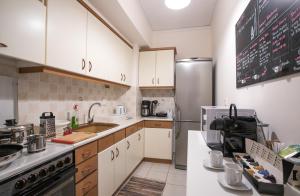 uma cozinha com armários brancos e um frigorífico de aço inoxidável em City apartment with private parking em Nafplio