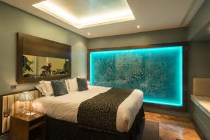 a bedroom with a large window with an aquarium at Le Monde Hotel in Edinburgh