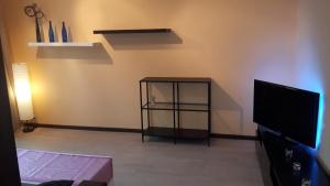 ein Wohnzimmer mit einem TV und einem Regal mit einer Schere in der Unterkunft Anne 80 Apartment in Tartu