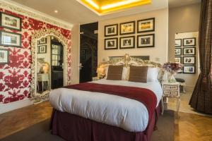 a bedroom with a large bed with red and white walls at Le Monde Hotel in Edinburgh