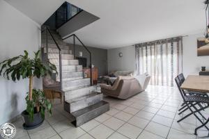 a living room with a staircase and a couch at Gite de la plaine in Saint-Ignat