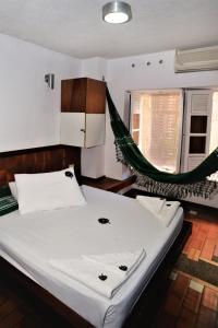 a bed with a hammock in a room at Laranjeiras Hostel in Salvador