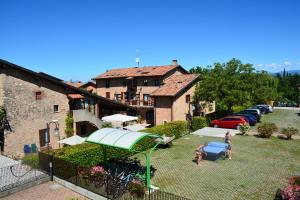 uma mulher parada num quintal ao lado de um edifício em Residenza Corte Casara em Lazise