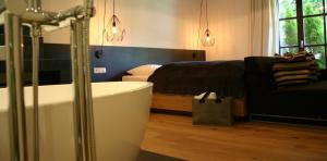ガシュルンにあるMONTAFONLodgeのバスルーム(バスタブ付)、ベッド1台、ソファが備わります。