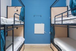 two bunk beds in a room with a blue wall at No Limit Barcelona Central in Barcelona