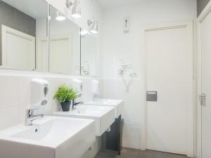 a white bathroom with three sinks and a mirror at No Limit Barcelona Central in Barcelona +51 photos