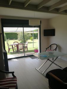 una sala de estar con una mesa y sillas de cristal en Chambres d'hôte de Sauviolle, en Frontenac