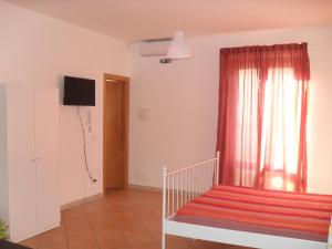 a living room with a red curtain and a window at Casa Del Padrino in Ispica